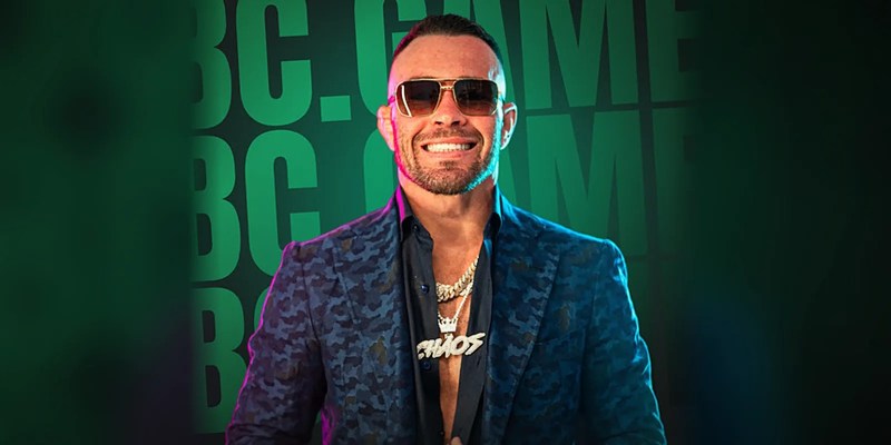 Colby Covington in a camouflage blazer in front of BC.GAME lettering